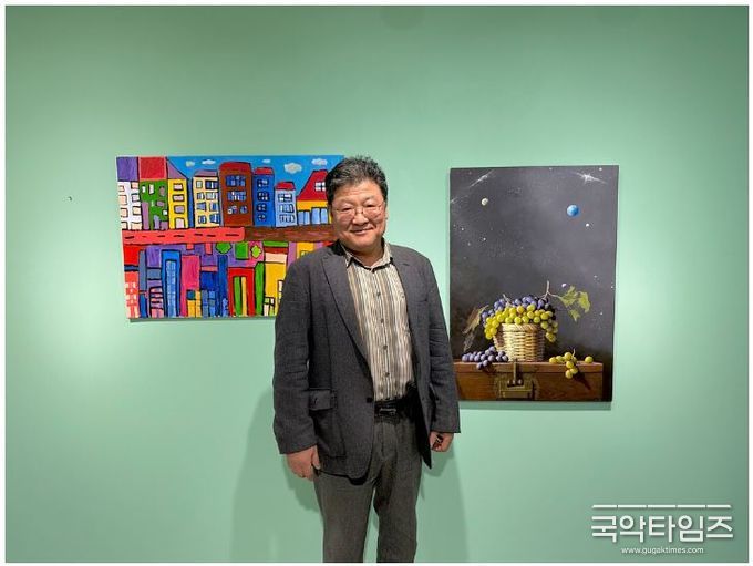 특별전에 참가하는 국내 유명 작가 정정식 화가가 비채뮤지엄에 걸린 발달장애 화가 최봄이의 '나는 다른 옷을 입고 있어요' (좌) 와 나란히 전시된 자신의 작품 '순환-옛날 옛적에'(우) 앞에서 포즈를 취하고 있다. (사진제공 세이아트 SayArt)