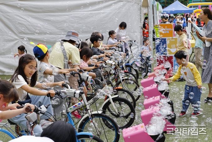 17일 우장산 축구장에서 열린 ‘2025 우장산 그린페스타’를 찾은 아이들이 자전거 발전기로 비눗방울을 만들고 있다.