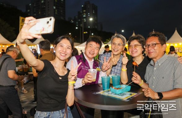 ‘2025 동대문구 맥주축제’를 즐기는 가족과 이필형 동대문구청장(보라색조끼)이 기념촬영을 하고 있다